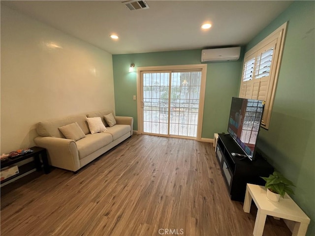 living room with wood-type flooring and an AC wall unit