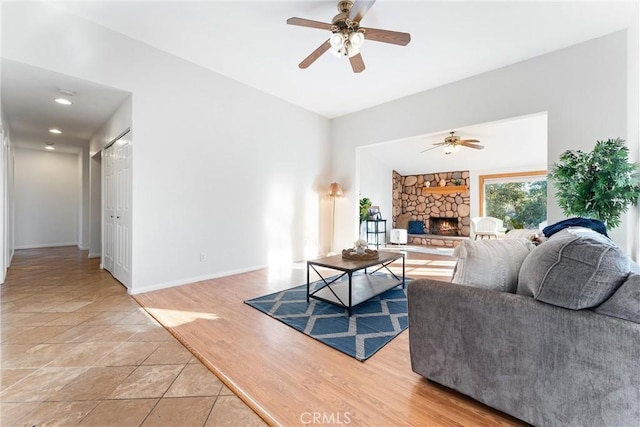 living room with ceiling fan, tile patterned floors, and a fireplace