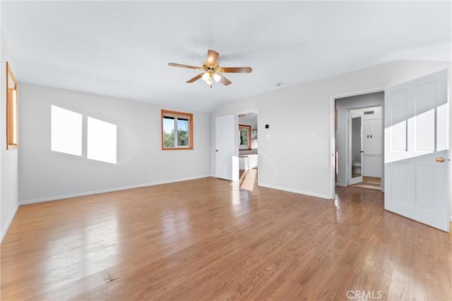 interior space with ceiling fan, vaulted ceiling, and light wood-type flooring