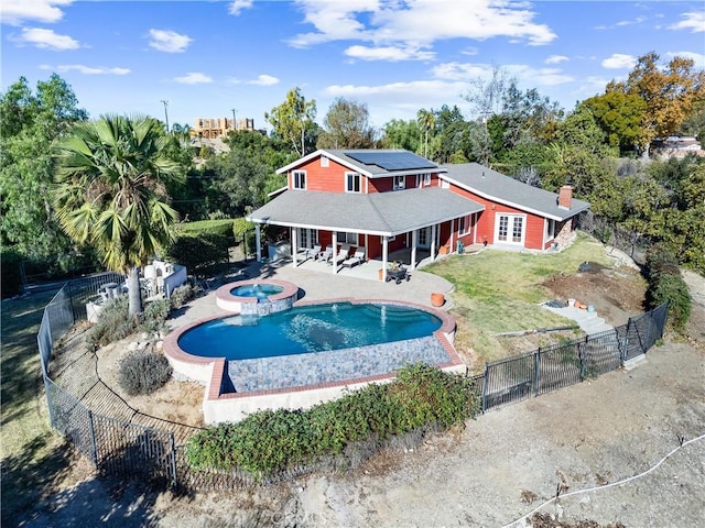 view of pool featuring a lawn, a patio, and an in ground hot tub