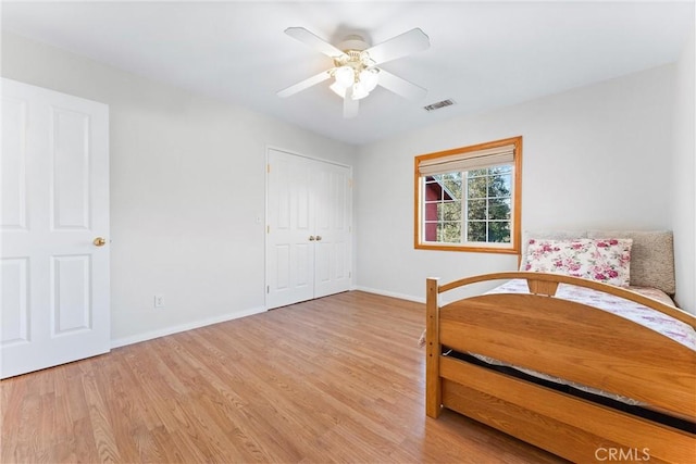 unfurnished bedroom with light hardwood / wood-style floors, a closet, and ceiling fan