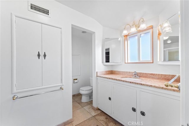 bathroom featuring vanity, tile patterned floors, and toilet