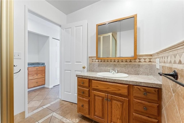 bathroom featuring tile patterned flooring, vanity, and walk in shower