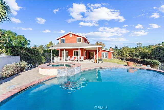 view of swimming pool with an in ground hot tub, a patio area, and an outbuilding