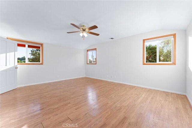 empty room with lofted ceiling, light hardwood / wood-style floors, and ceiling fan