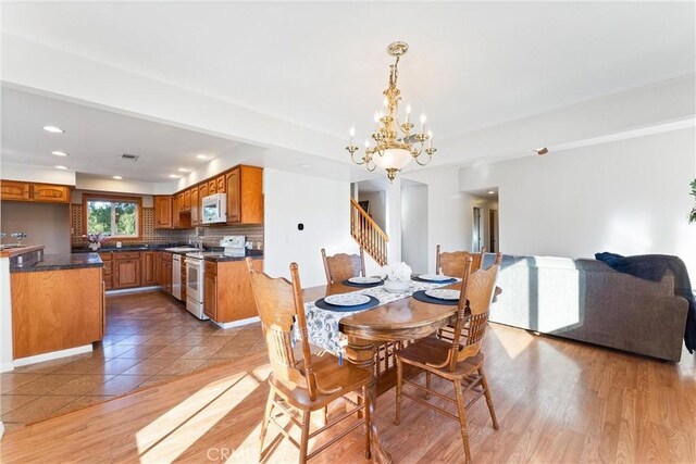 tiled dining room featuring an inviting chandelier