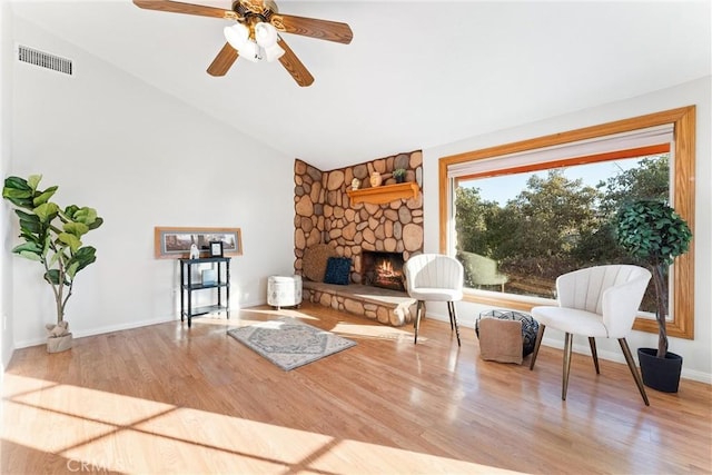 living area featuring ceiling fan, a fireplace, vaulted ceiling, and hardwood / wood-style floors