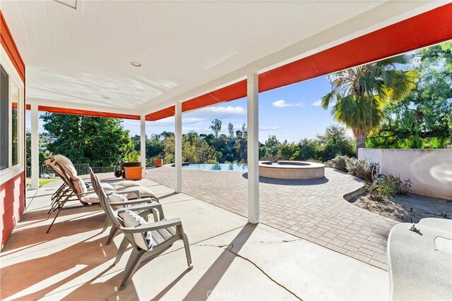 view of patio featuring a water view and a swimming pool with hot tub