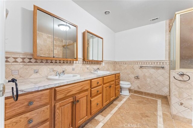 bathroom with vanity, tile walls, an enclosed shower, and toilet