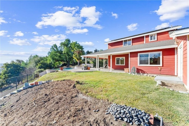 back of property with a lawn and a patio