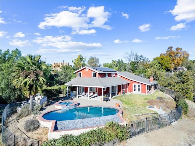 view of swimming pool with an in ground hot tub, a lawn, and a patio area