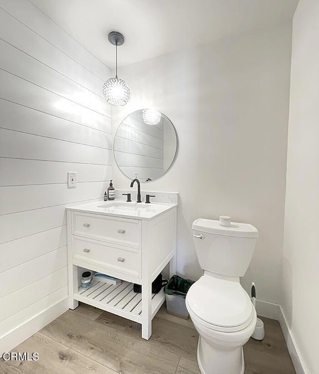 bathroom featuring wood-type flooring, vanity, and toilet