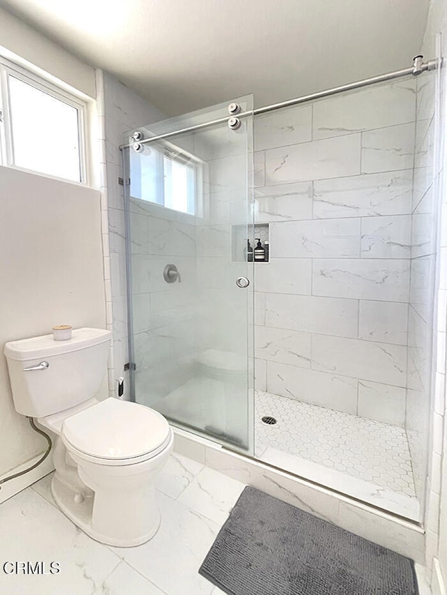 bathroom featuring walk in shower and toilet