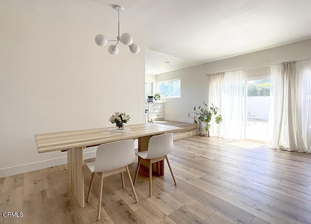 dining space with an inviting chandelier and light wood-type flooring