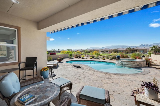 view of swimming pool featuring an in ground hot tub and a patio