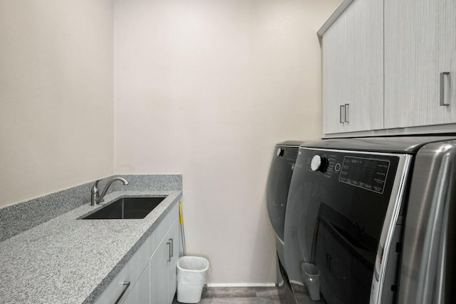 laundry room with cabinets, sink, and washing machine and dryer