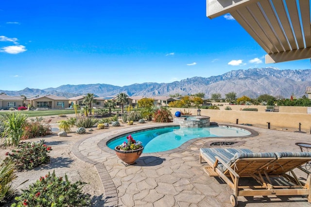 view of swimming pool featuring an in ground hot tub, a mountain view, and a patio area