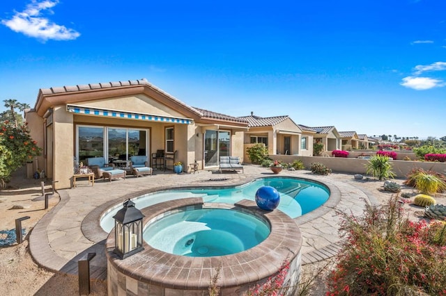 rear view of property with a swimming pool with hot tub and a patio area