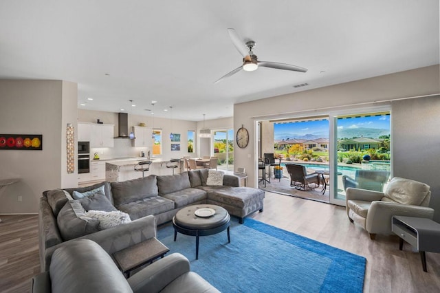 living room featuring ceiling fan and light hardwood / wood-style floors