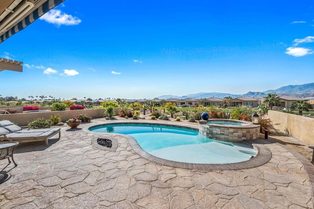 view of pool with a patio, a mountain view, and an in ground hot tub