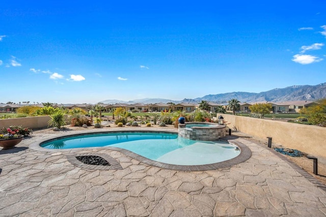 view of pool with an in ground hot tub, a mountain view, and a patio