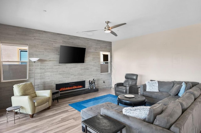 living room with a fireplace, light hardwood / wood-style floors, and ceiling fan