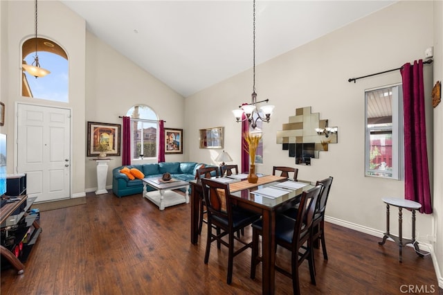 dining space featuring high vaulted ceiling, an inviting chandelier, and dark hardwood / wood-style flooring