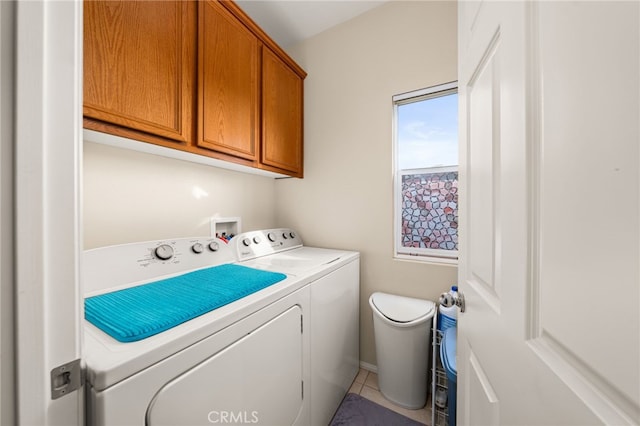 clothes washing area featuring cabinets and independent washer and dryer