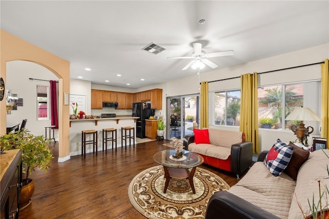 living room featuring dark wood-type flooring and ceiling fan