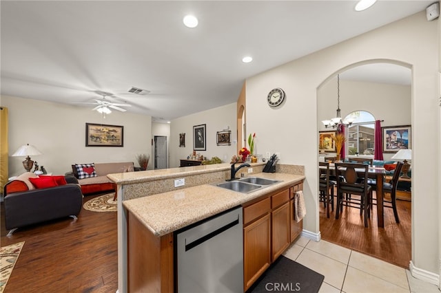 kitchen featuring sink, hanging light fixtures, ceiling fan with notable chandelier, stainless steel dishwasher, and kitchen peninsula