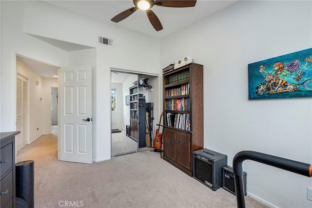 interior space featuring light colored carpet and ceiling fan