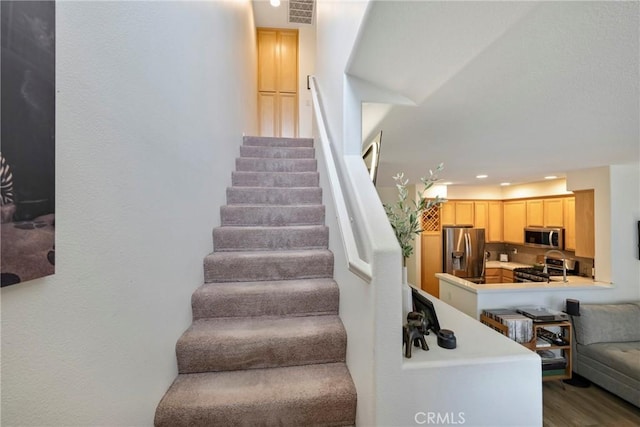 staircase with hardwood / wood-style floors