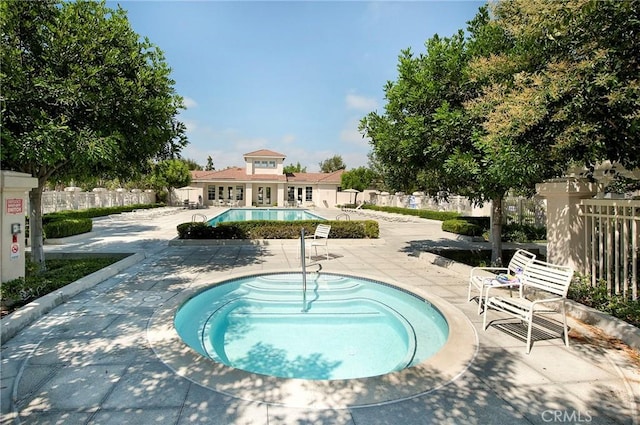 view of pool featuring a hot tub and a patio