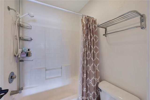 bathroom featuring shower / bathtub combination with curtain and toilet