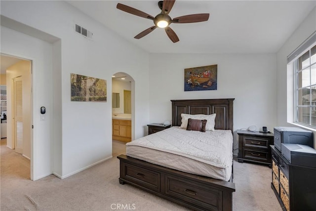 bedroom with light carpet, lofted ceiling, ceiling fan, and ensuite bathroom