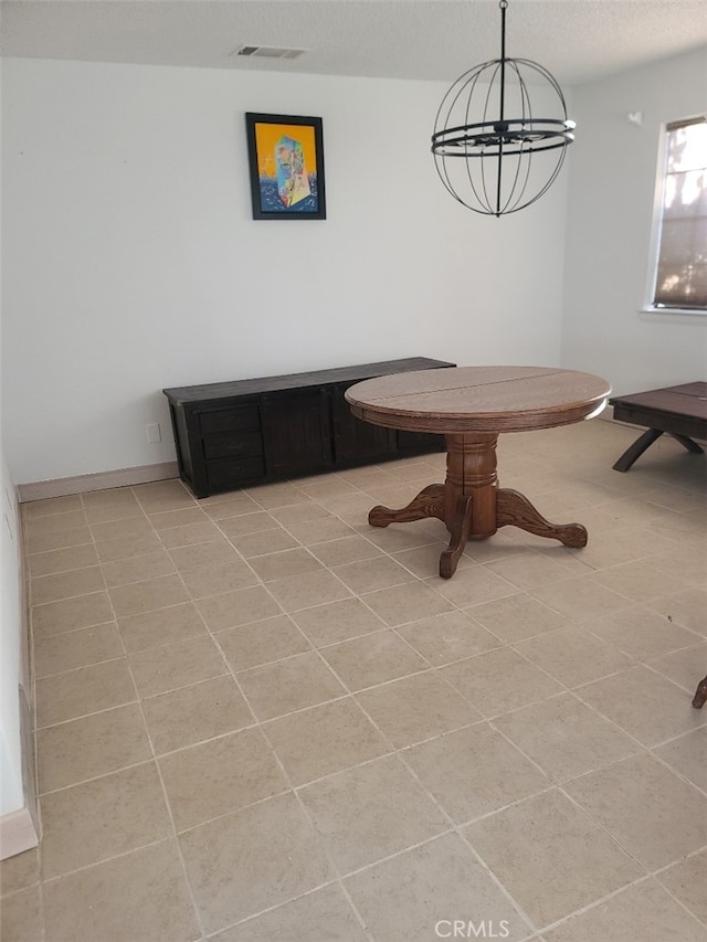 tiled dining room with a notable chandelier