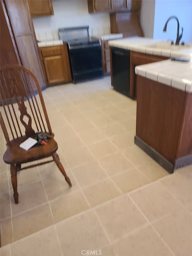 kitchen with dishwasher, stove, tile countertops, and light tile patterned flooring