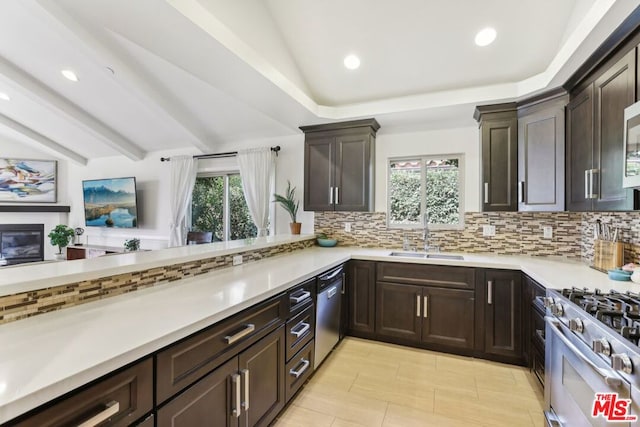 kitchen with tasteful backsplash, sink, kitchen peninsula, stainless steel appliances, and dark brown cabinets