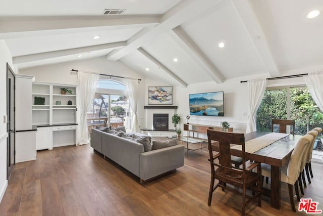 living room with lofted ceiling with beams, a wealth of natural light, and dark hardwood / wood-style flooring