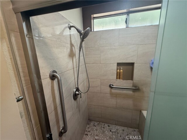 bathroom with a shower with door