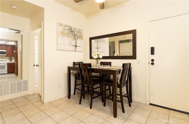 tiled dining space featuring ceiling fan