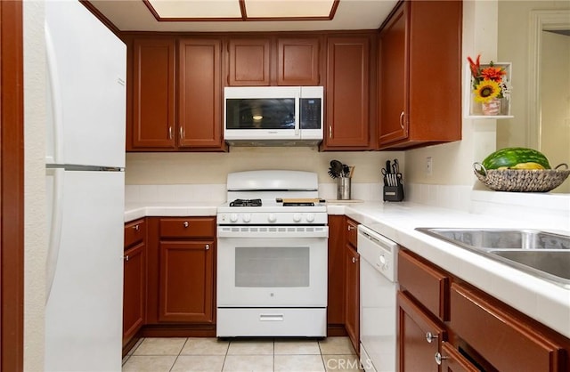 kitchen featuring light tile patterned floors and white appliances