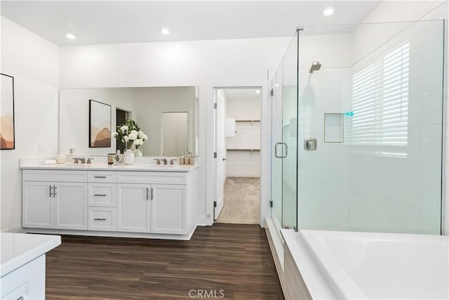 bathroom featuring vanity, hardwood / wood-style floors, and plus walk in shower