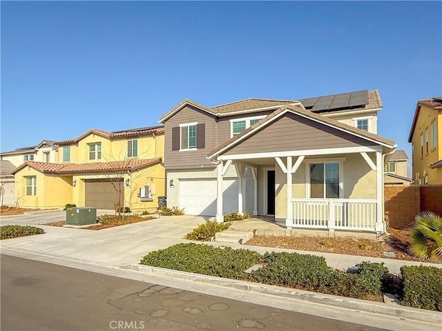 view of front of property featuring a garage, covered porch, and solar panels