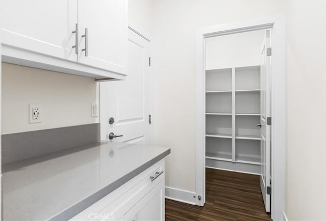 interior space featuring dark wood-type flooring and white cabinets