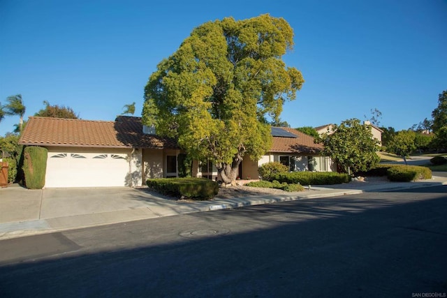 view of front of home with a garage and solar panels