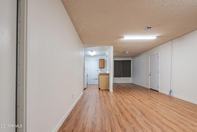 empty room featuring light hardwood / wood-style flooring and a textured ceiling