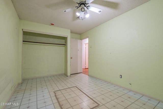 unfurnished bedroom with a textured ceiling, ceiling fan, and a closet