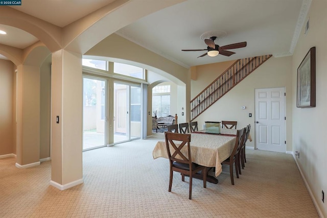 dining room featuring light carpet, crown molding, and ceiling fan