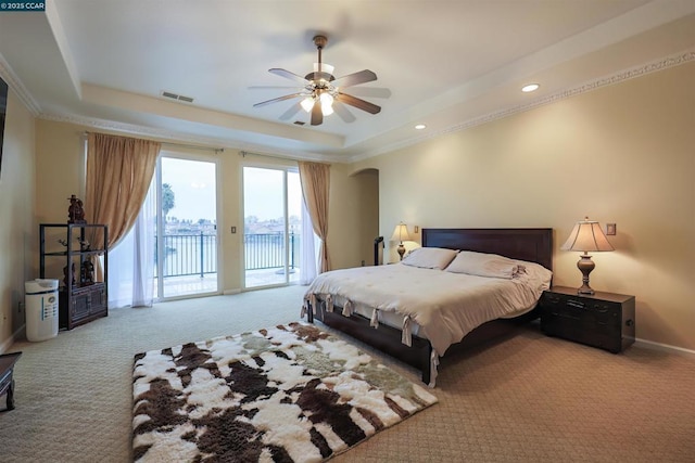 carpeted bedroom with crown molding, access to outside, ceiling fan, and a tray ceiling